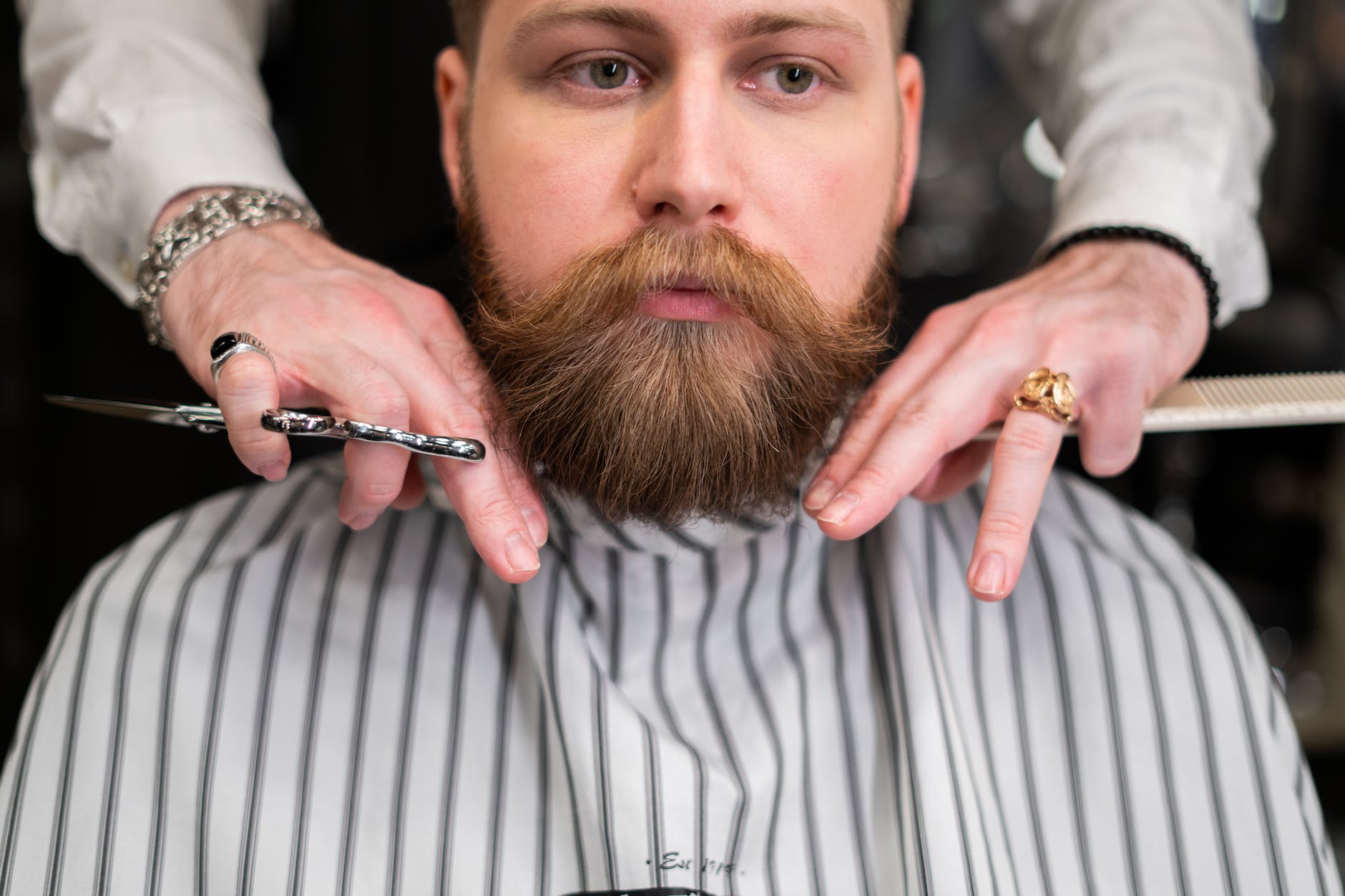 man in white and gray pinstripe having a haircut